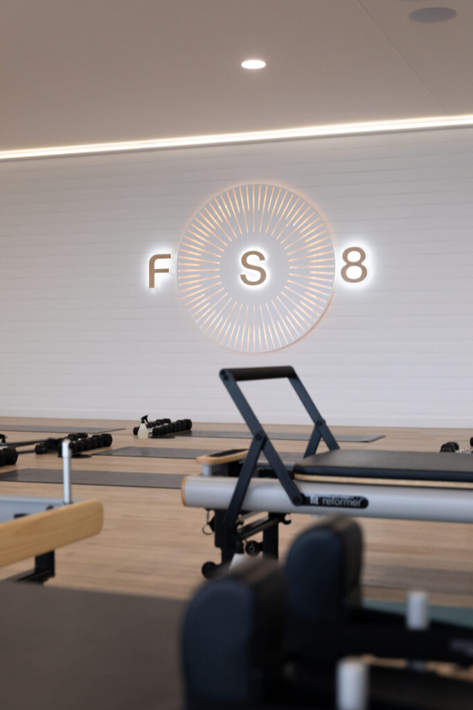 Floor to ceiling windows, on-brand LED signage and pilates reformers for this wellness & fitness fit out for FS8