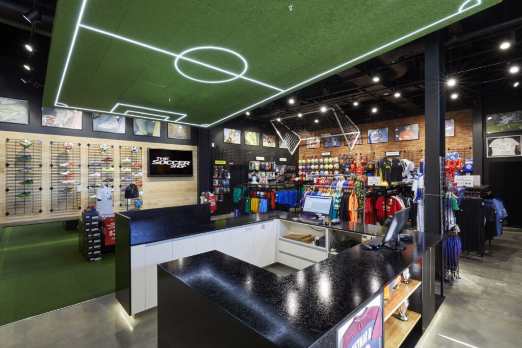 Durable concrete flooring, custom ceiling LED soccer table and bespoke merchandise displays for this retail fit out for The Soccer Shop