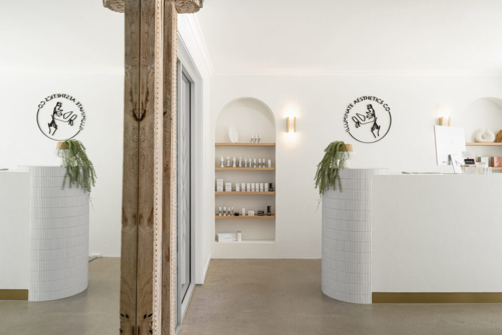 Neutral colour palette, circular pendant wall lights and welcoming reception area for this medical fit out for Illuminate Aesthetics