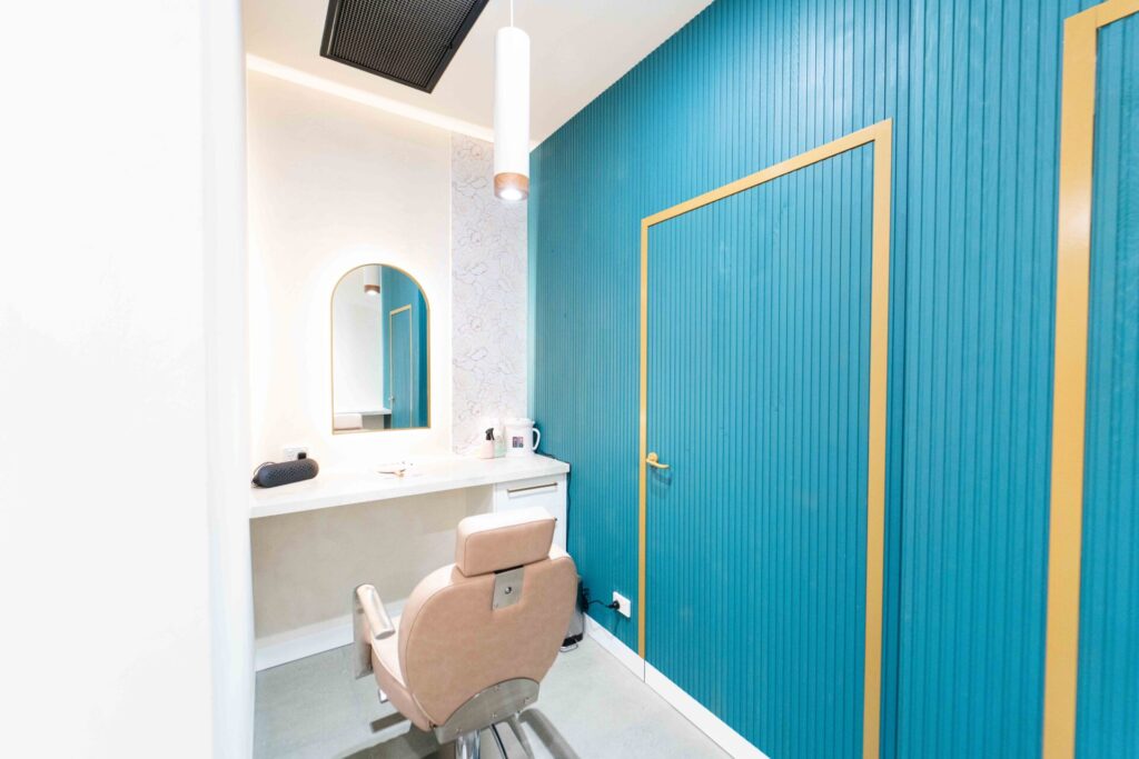 Light pink chairs, blue and gold colour palette with neutral splashbacks and welcoming reception area for this wellness & beauty fit out for Just Brows and Beauty