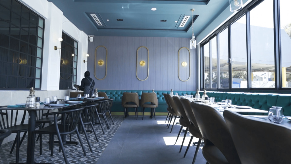 Circular gold wall custom lighting, blue toned Mediterranean colour palette and welcoming dining area for this hospitality fit out for Lazeez Lebanese