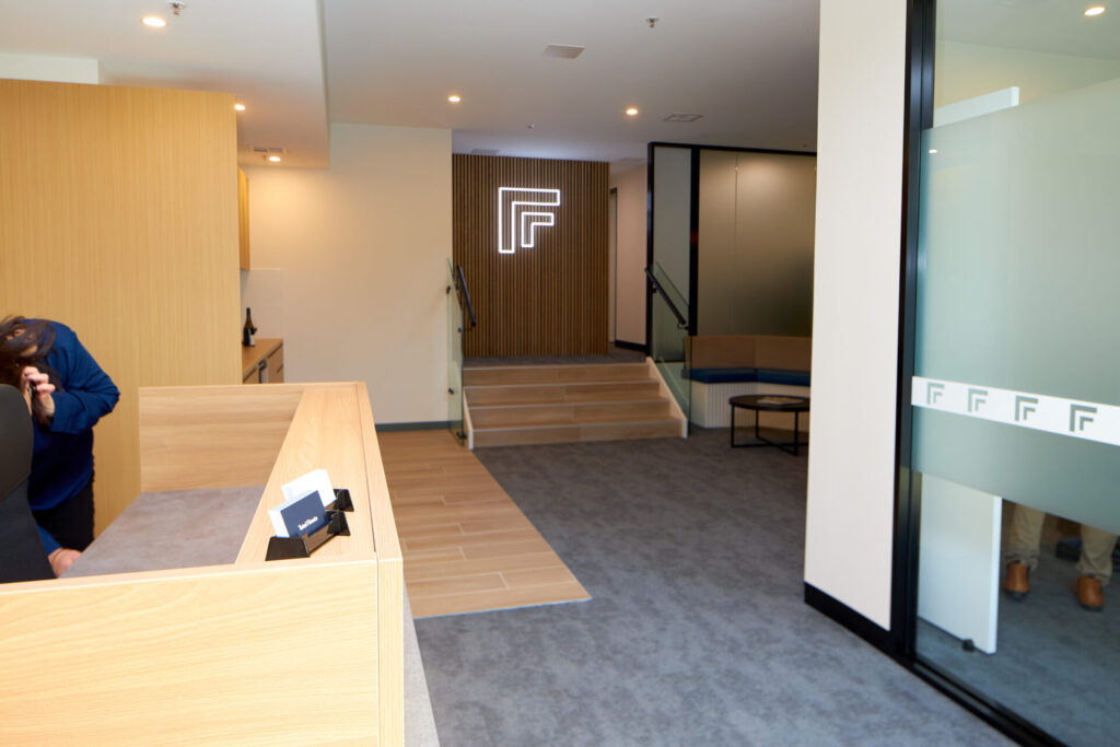 Neutral colour palette, custom plant feature wall and bespoke LED signage for this office fit out for Total Fitouts Canberra North design office
