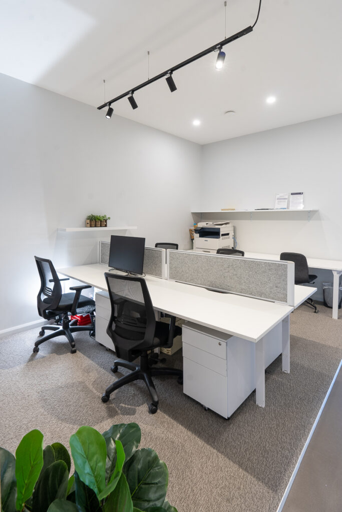 Neutral colour palette, hanging pendant lighting and welcoming reception area for this office fit out for McGrath Nowra