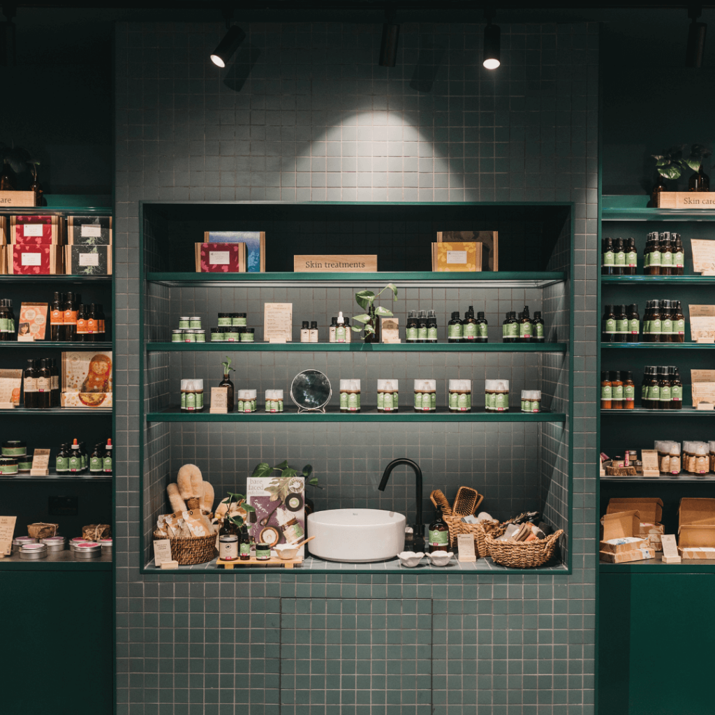 Deep green colour palette, square tile feature wall and bespoke merchandise displays for this retail fit out for Perfect Potion