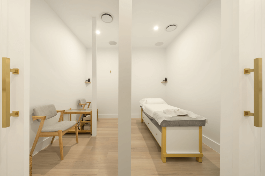 Brass and white colour palette, ample wall and ceiling lights and timber flooring for this wellness & beauty fit out for Square Massage and Acupuncture Noosa