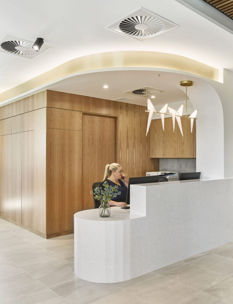 Concrete bespoke reception desk, large custom timber screens and neutral coastal colour palette for this medical fit out for Greenslopes Medical, Total Fitouts Brisbane