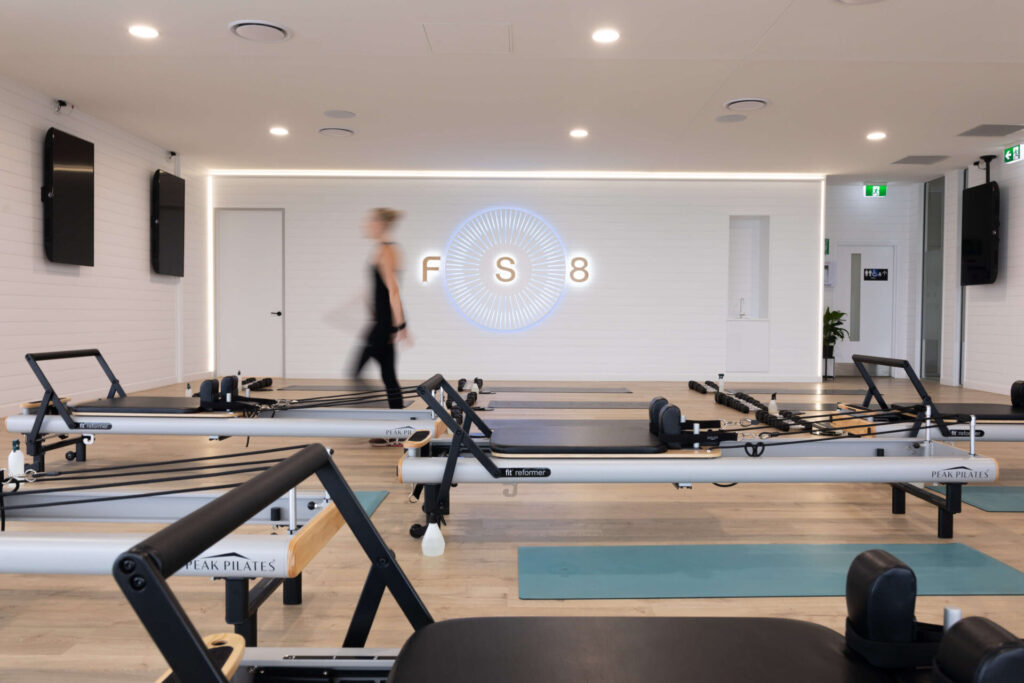Light colour palette, high end reformer beds and custom LED signage for this fitness fit out for FS8