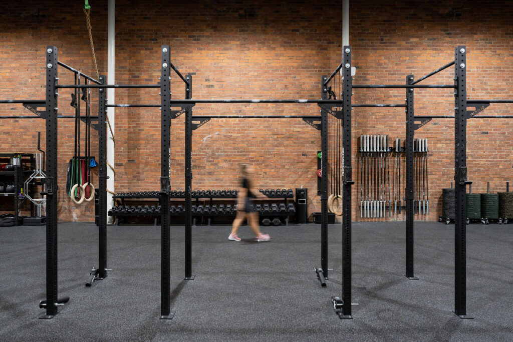 Black and white branded colour palette, high end black gym equipment and original brick feature wall for this commercial fitness fit out for 98 Gym