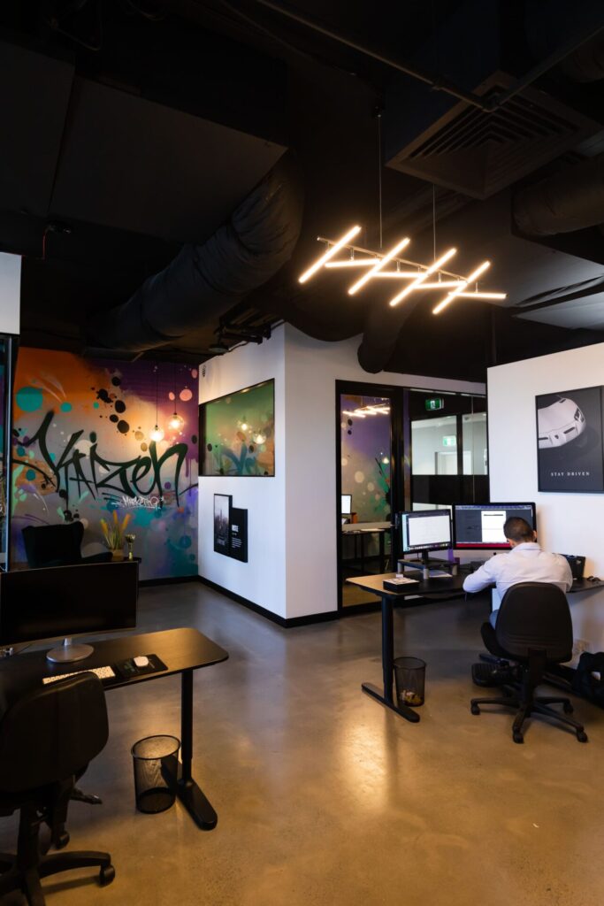 Custom spray paint wall mural, black and white simple colour palette to compliment contrasting spray paint and flexible office work area for this office fit out for Kaizen Marketing, Total Fitouts Sunshine Coast North