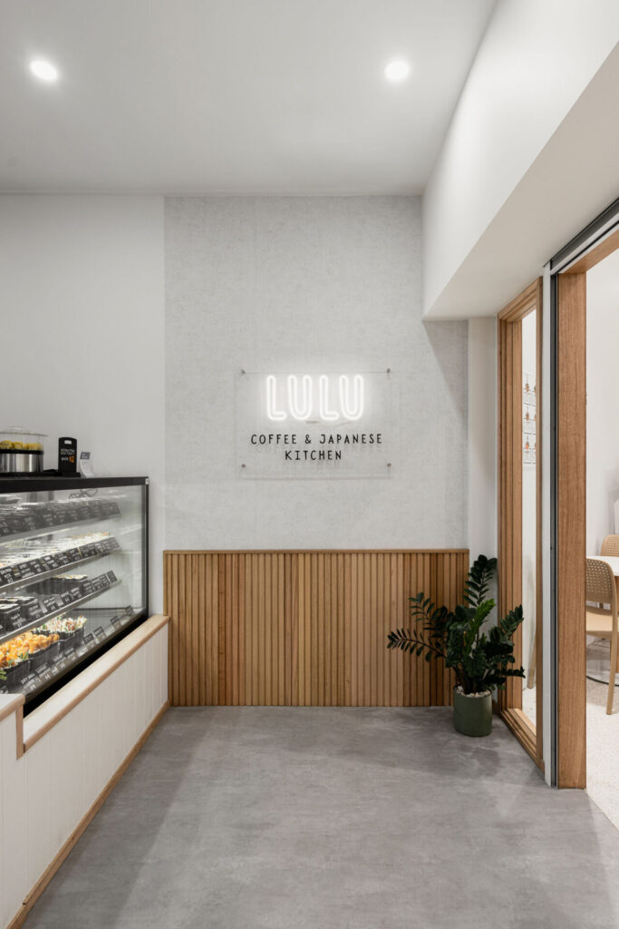 Timber wall panelling and framing, custom LED light signage and neutral colour palette for this hospitality fit out for Lulus Coffee and Japanese Kitchen, Total Fitouts Wide Bay